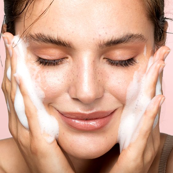 Girl washing her face with a foaming cleanser.