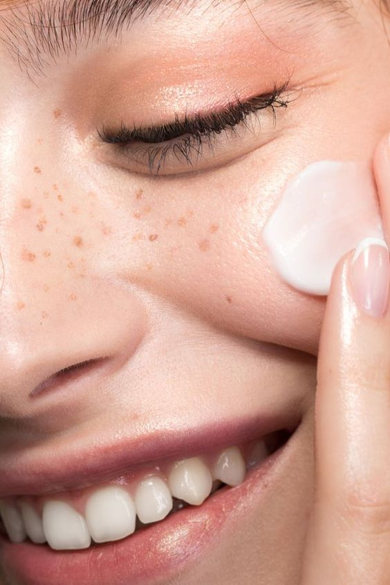 Girl applying moisturizer.