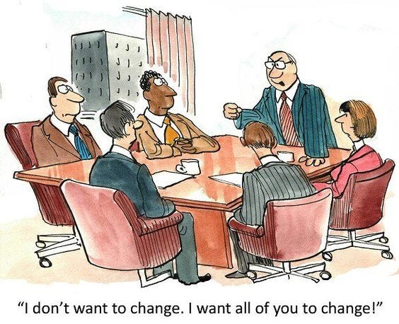Groupe de travail en réunion, le Patron, debout, dit, traduit de l’anglais: Je ne veux pas changer, je veux que vous changiez