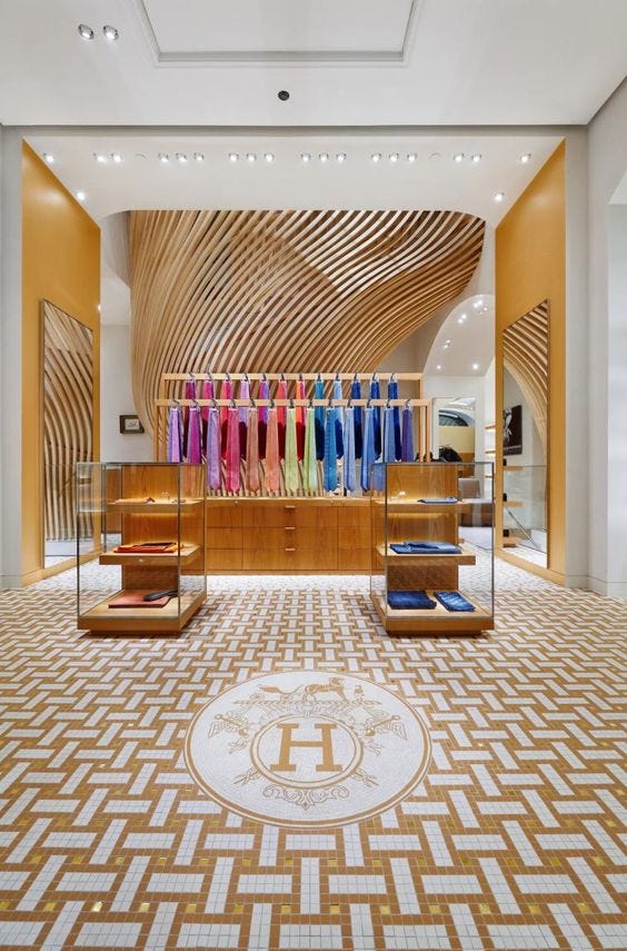 Hermes store with rack of colorful clothes and emblem on the floor
