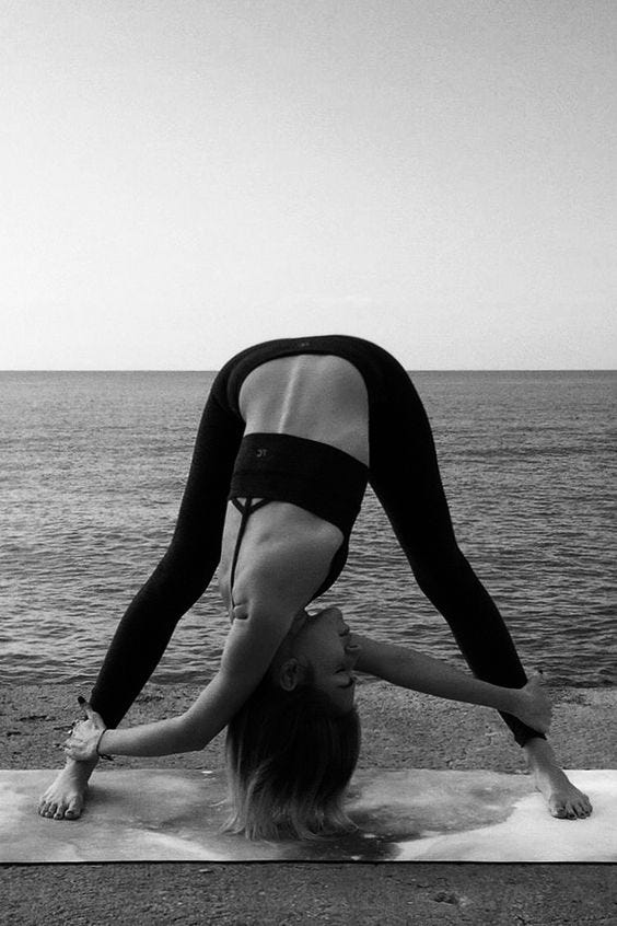 A girl in the sea practicing yoga.