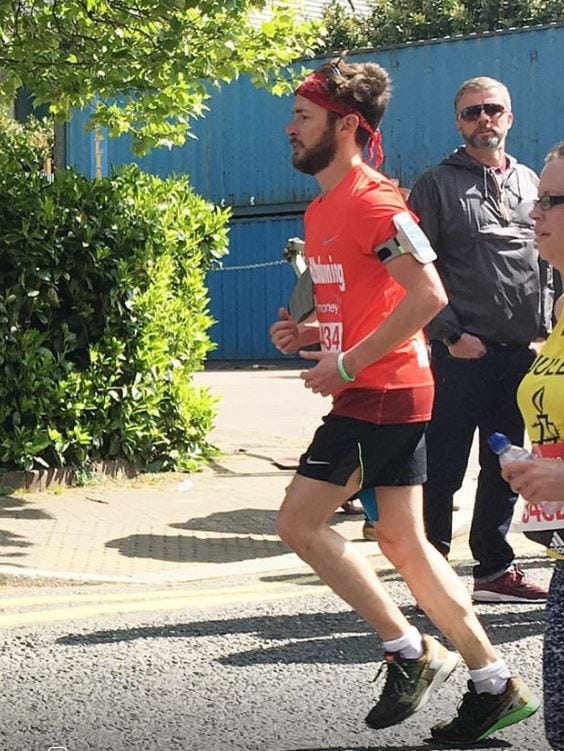 Alex Innes in a red T shirt running the London marathon in 2017 on a sunny day