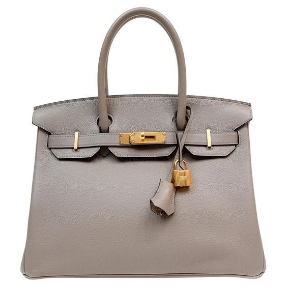 A grey chevre leather Birkin bag with golden hardware.