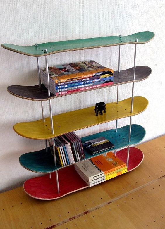 A standing shelf for books made out of skate boards.