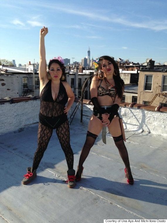 A photo of the Osato sisters on a roof. The sister on the left has a fist in the air; the other is holding a large knife.