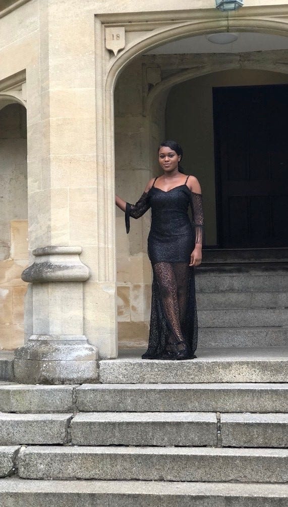 Esther Agbolade stands on outdoor steps