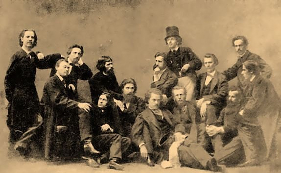 An old sepia photography, showing fifteen men, obviously of XIXth century artistic persuasion, in a tableau composition, sitting and standing in random poses.