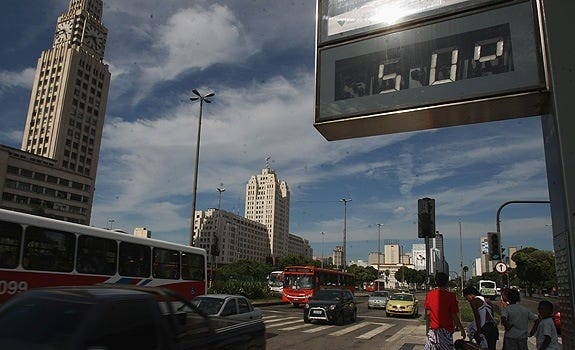Um relógio de rua marca a temperatura de 50 graus. À esquerda está o prédio da Central do Brasil, no Rio de Janeiro.