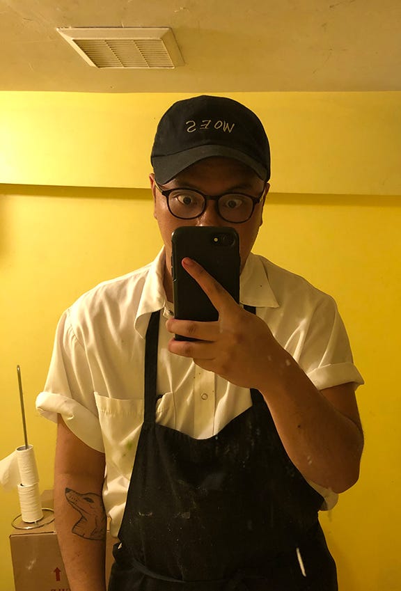 A person taking a selfie, wearing a cook uniform.