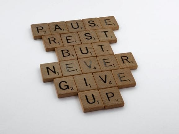 Pause rest but never give up arranged with scrabble letters