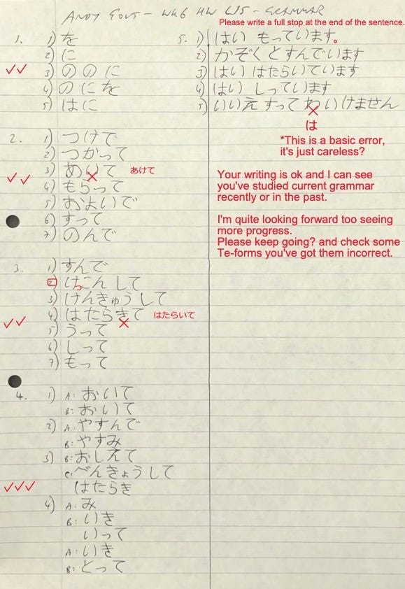 A sheet of lined A4 paper on which is written a student’s Japanese homework along with the teacher’s comments.