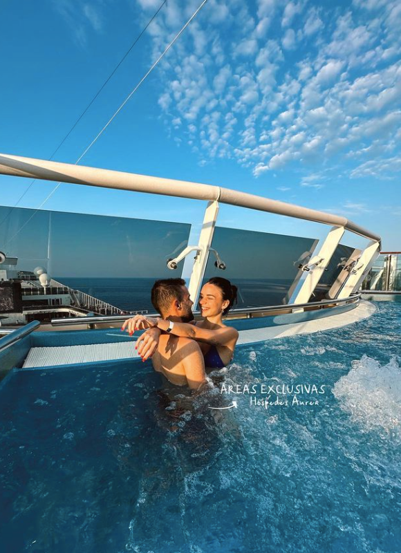 The photo shows the two influenceurs embracing in a pool of a boat, the tones are mainly blue.