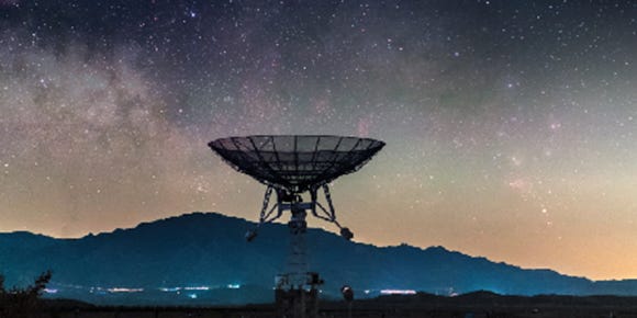 satellite dish with the silhouette of a mountain and a starry sky