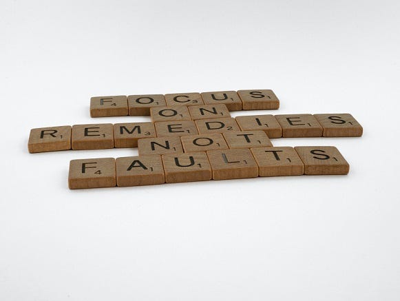 Scrabble tiles arranged to read “Focus on remedies not faults”.