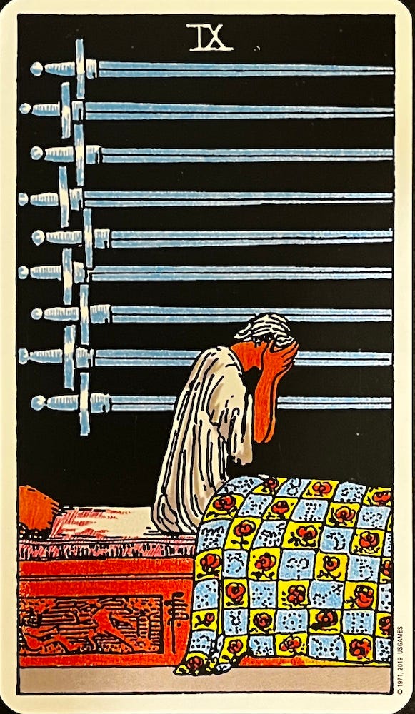 Tarot Card — Nine of Swords. A Man sits up in bed holding his head in his hands. Nine swords appear on the wall behind him.