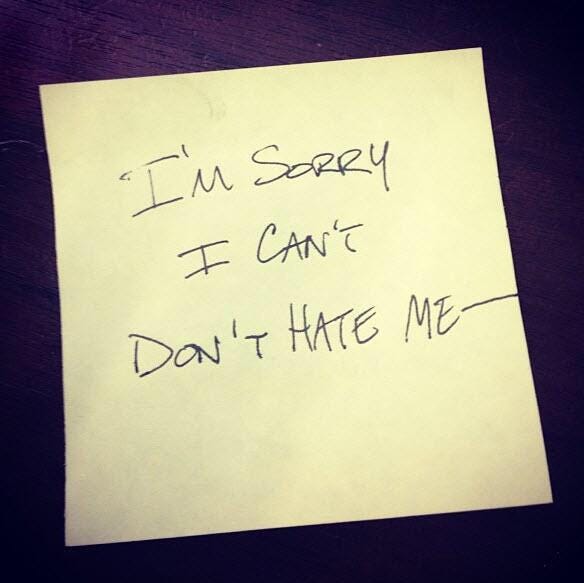 A post-it note with the words “I’m sorry I can’t don’t hate me” in all capitals.