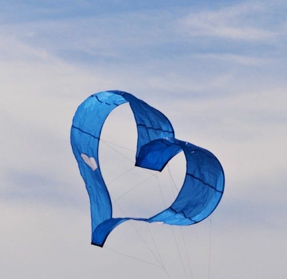Blue heart shaped kite flying in the sky