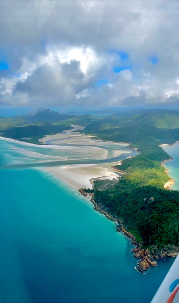 Aerial view of Whitehaven Beach from above during the Heart Reef flight, showcasing pristine white sands and turquoise waters, a stunning natural wonder in the Whitsunday Islands, Queensland, Australia.