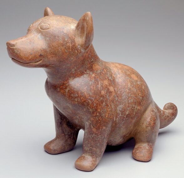 A sculpture of a dog from Mexico sits on its hind legs with a half-smile on its face.