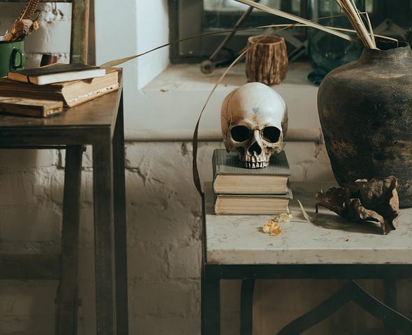 A picture of a skull on a stack of books on a table