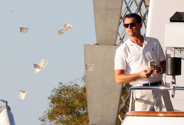 Actor Leonardo DiCaprio throwing money from a yacht.