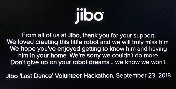 A text on Jibo's screen: "From all of us at Jibo, thank you for your support. We loved creating this little robot and we will truly miss him. We hope you' ve enjoyed getting to know him and having him in your home. We’re sorry we couldn’t do more. Don’t give up on your robot dreams… we know we won’t. Jibo ‘Last Dance’ Volunteer Hackathon, September 23, 2018"