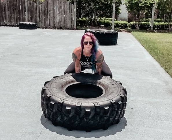 Megan Fuller lifting a tyre as part of her workout.