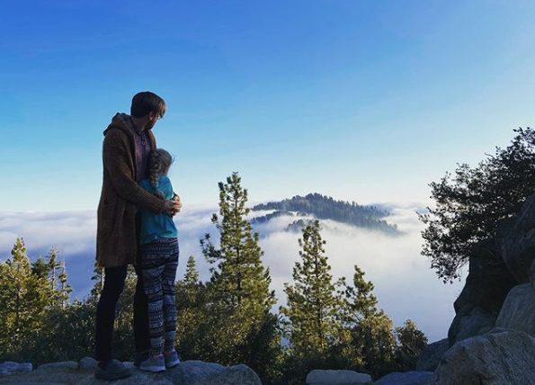 Brett Lark and Tehya Mae hugging and looking out above the clouds.