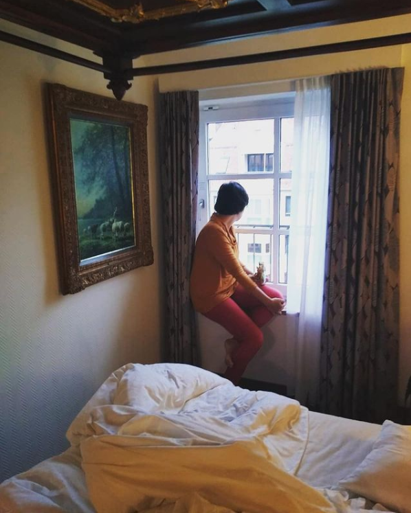 Elissa está num quarto de hotel, sentada numa janela, olhando para o lado de fora. A janela possui cortinas de ambos os lados, a parte de cima da roupa de Elissa é laranja e sua calça, rosa. Na parede do quarto, à esquerda, está pendurado um quadro grande com a pintura de uma floresta. No canto inferior da foto se encontra uma cama com os lençóis desarrumados.