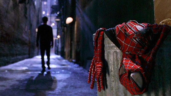 Imagem do filme Homem-Aranha 2. O protagonista Peter Parker caminha pra longe em um beco escuro, distanciando-se de seu uniforme de super-herói, deixado no lixo.