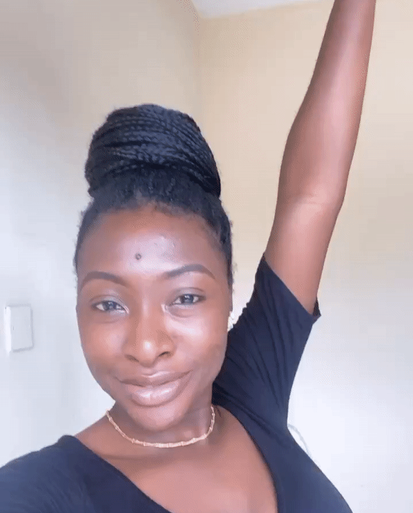 A gif of the author of this story, a young Nigerian woman, smiling with hand in the air. As if to celebrate her time at home.