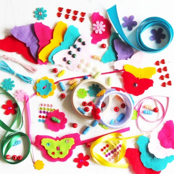 Brightly coloured felt cutouts, sequins, ribbons and bracelets on a table