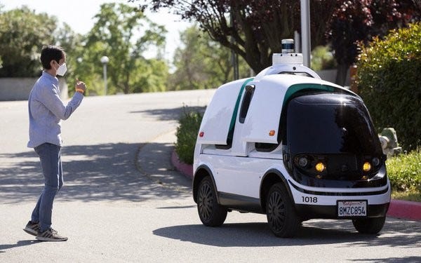 A Nuro autonomous vehicle pictured with a medical service worker.