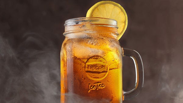 Glass of Long Island Iced Tea with lemon slice.