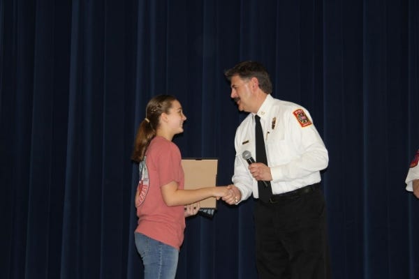 Her local fire chief surprising her at school with the 