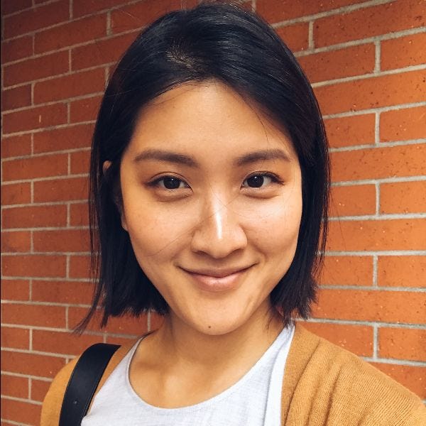 Headshot photo of a smiling Yehsong Kim wearing a light top with caramel-colored sweater