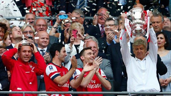 Arsenal manager Wenger lifts the trophy as he celebrates with his players their victory against Hull City in their FA Cup final at Wembley Stadium in London