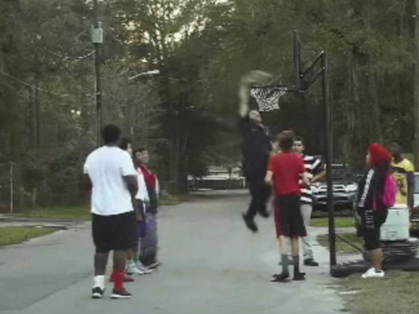 The kids watching in amazement as Officer White slam dunks. (Once the hoop was lowered, of course.)