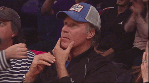 A GIF of Will Ferrell in the audience of a sports game, making a thinking gesture, slowly turning to look into the camera