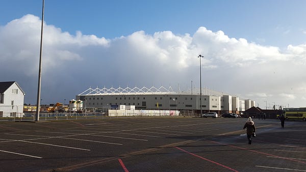 A snap, by me, of Blackpool football club 30 minutes before a game. This car park and that stadium used to be full of cars and coaches carrying both home and away fans who spent money in Blackpool.