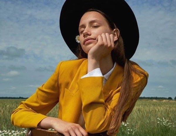 Model poses in mustard yellow suit