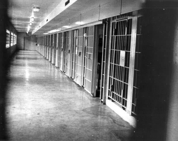 A black and white image of the hallway and cells of death row at Florida State Prison.