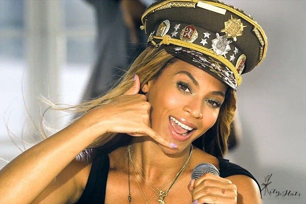 Beyonce from her “Love on Top” music video gesturing a phone with her hand