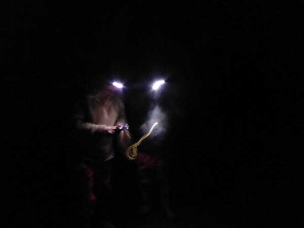 A blurred picture of two people wearing head torches.