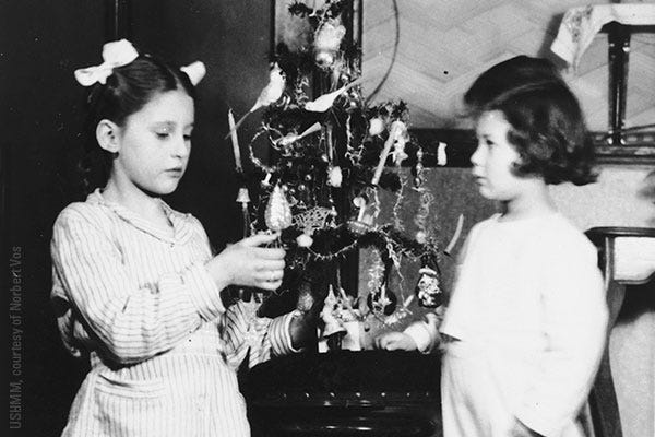 Norbert Obstfeld (right) poses next to a Christmas tree with Raymonda Verhage, the daughter of his rescuers, in December 1943.