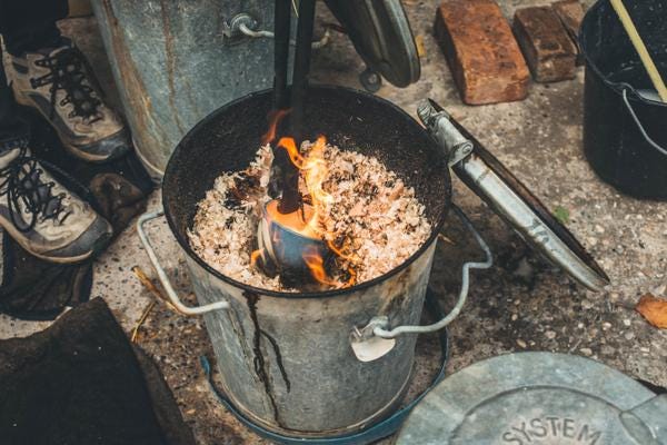 Metal bin of sawdust for raku firing