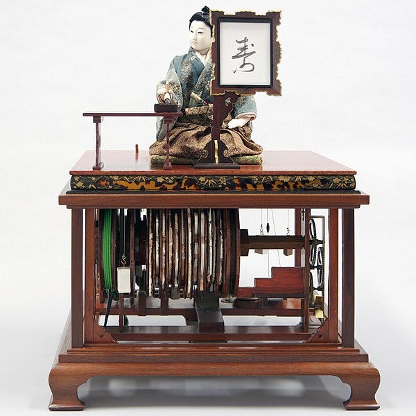 A Japanese doll sits on top of an old wooden mahogany furniture with mechanisms below her