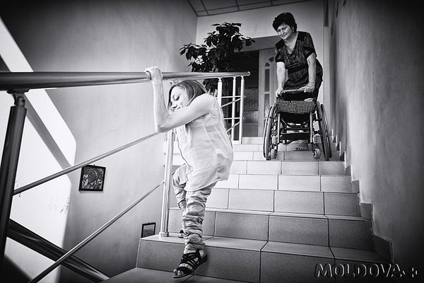 În imagine Elena și mama sa, Varvara. Tânăra coboară singură scările, este un efort deosebit pentru ea. (Foto: Igor Rotari, 8 septembrie 2015, s.Peresecina, raionul Orhei)