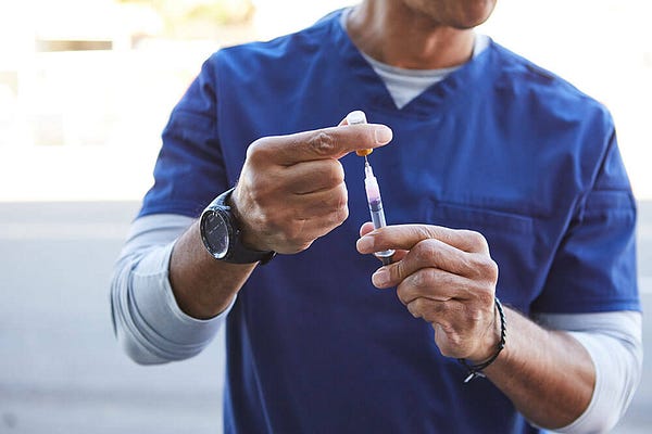 A vet's hands prepping medicine in a syringe 