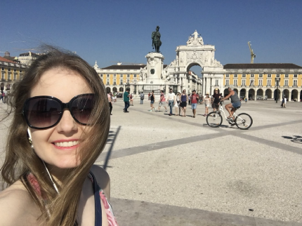 Selfie taken by Franciele at Terreiro do Paço, Lisbon. On the back there's the Arch of Rua Augusta